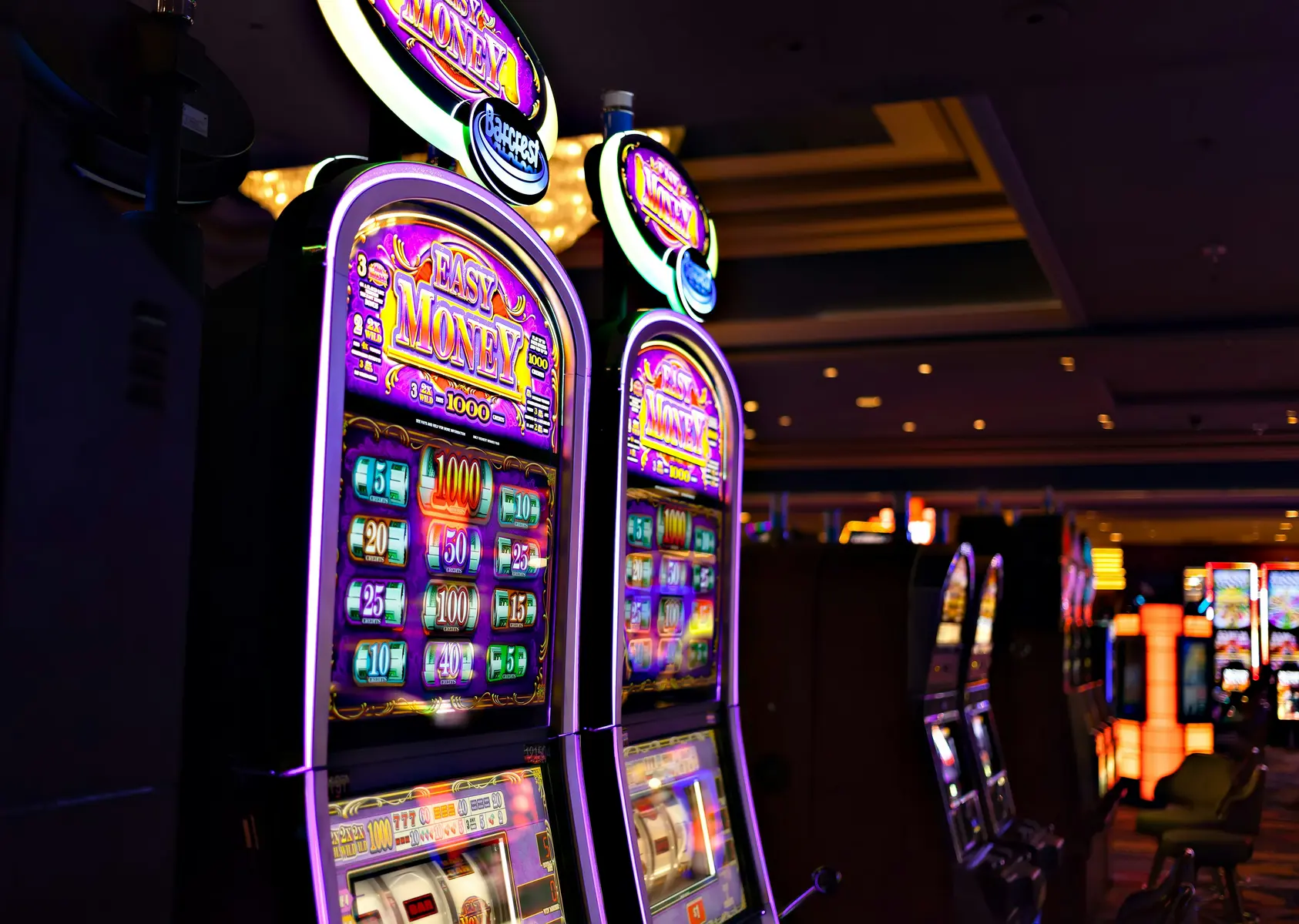Eine Reihe von leuchtenden Spielautomaten in einem Casino.