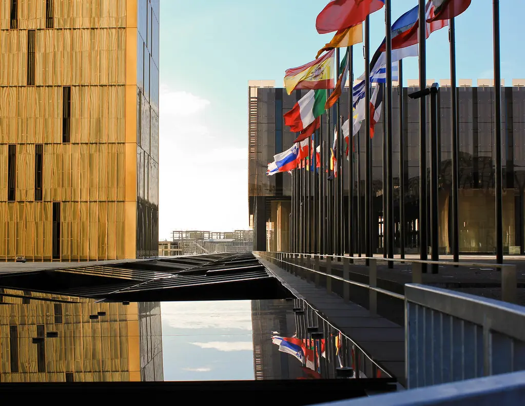 Außenansicht des Gebäudes des Europäischen Gerichtshofs mit einer Reihe von Nationalflaggen der EU-Mitgliedstaaten.