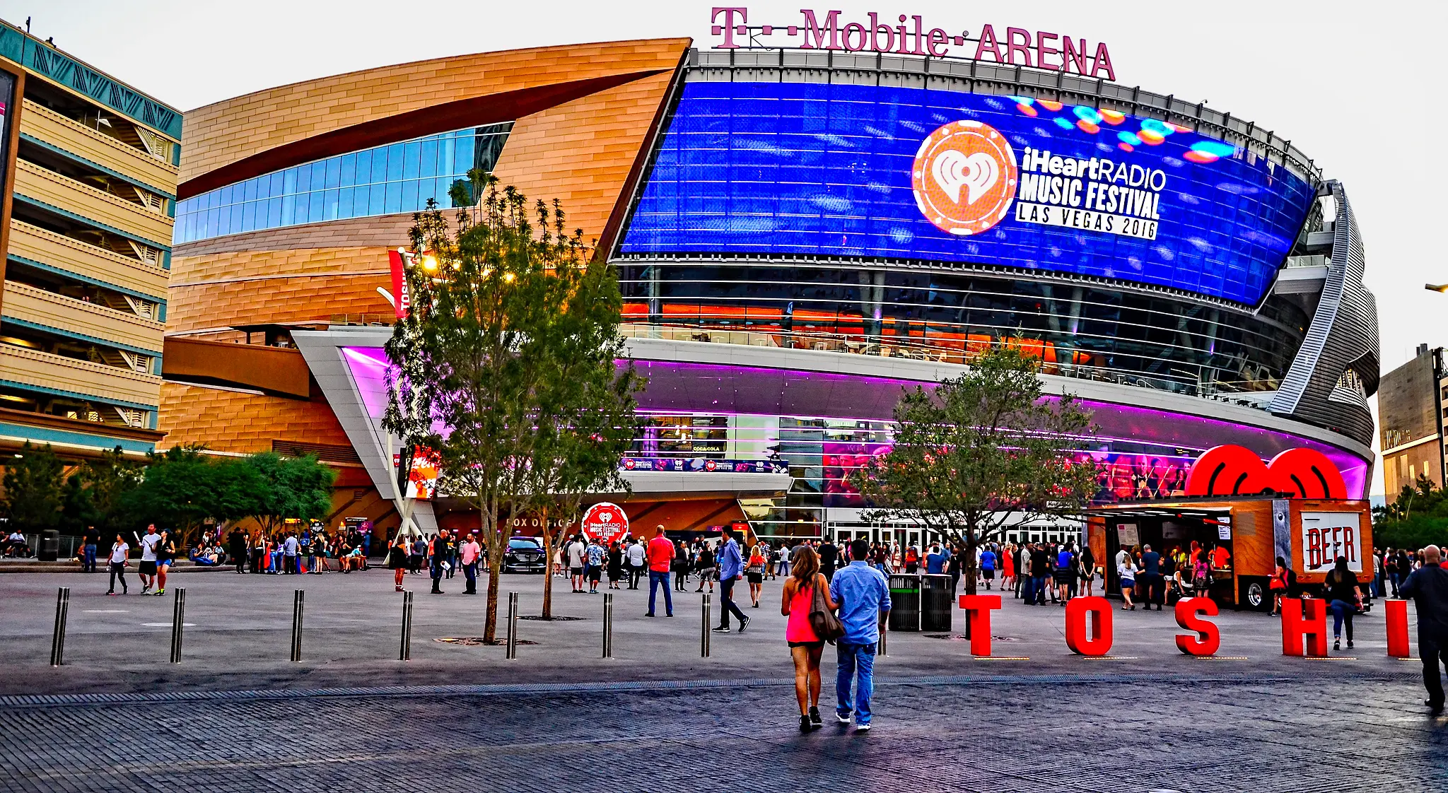 Außenansicht der T-Mobile Arena in Las Vegas mit einem großen digitalen Display für ein Musikfestival.