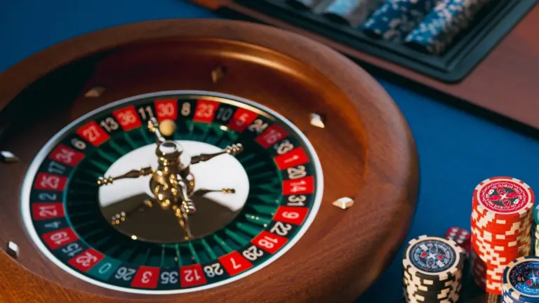 En roulettehjul och staplar med casinomarkörer på ett blått bord