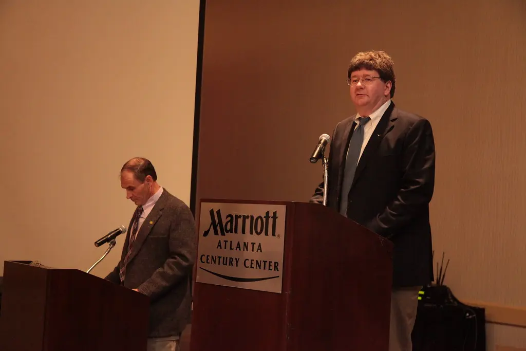 Patrick Leonard talar vid ett podium på Marriott Atlanta Century Center.
