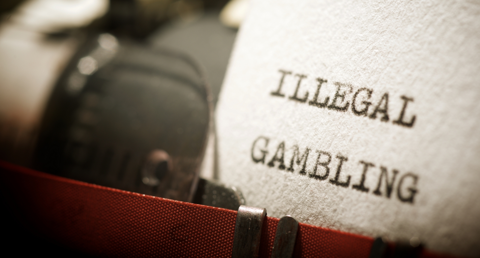 A picture of a typewriter with "Illegal Gambling" written on a piece of paper