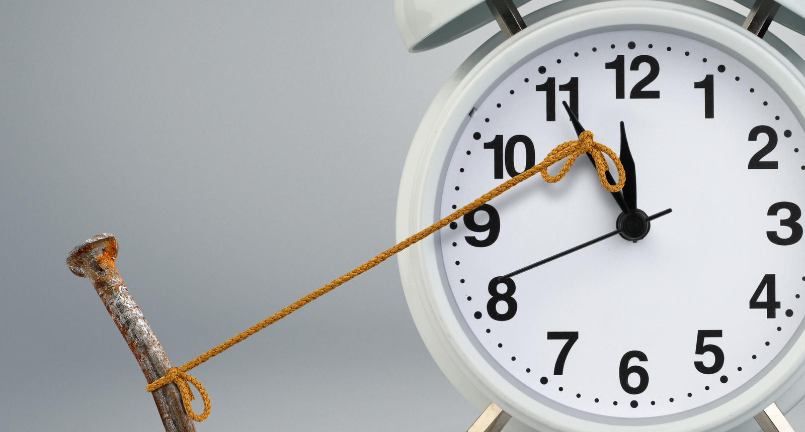 A picture of a nail holding back a clock hand