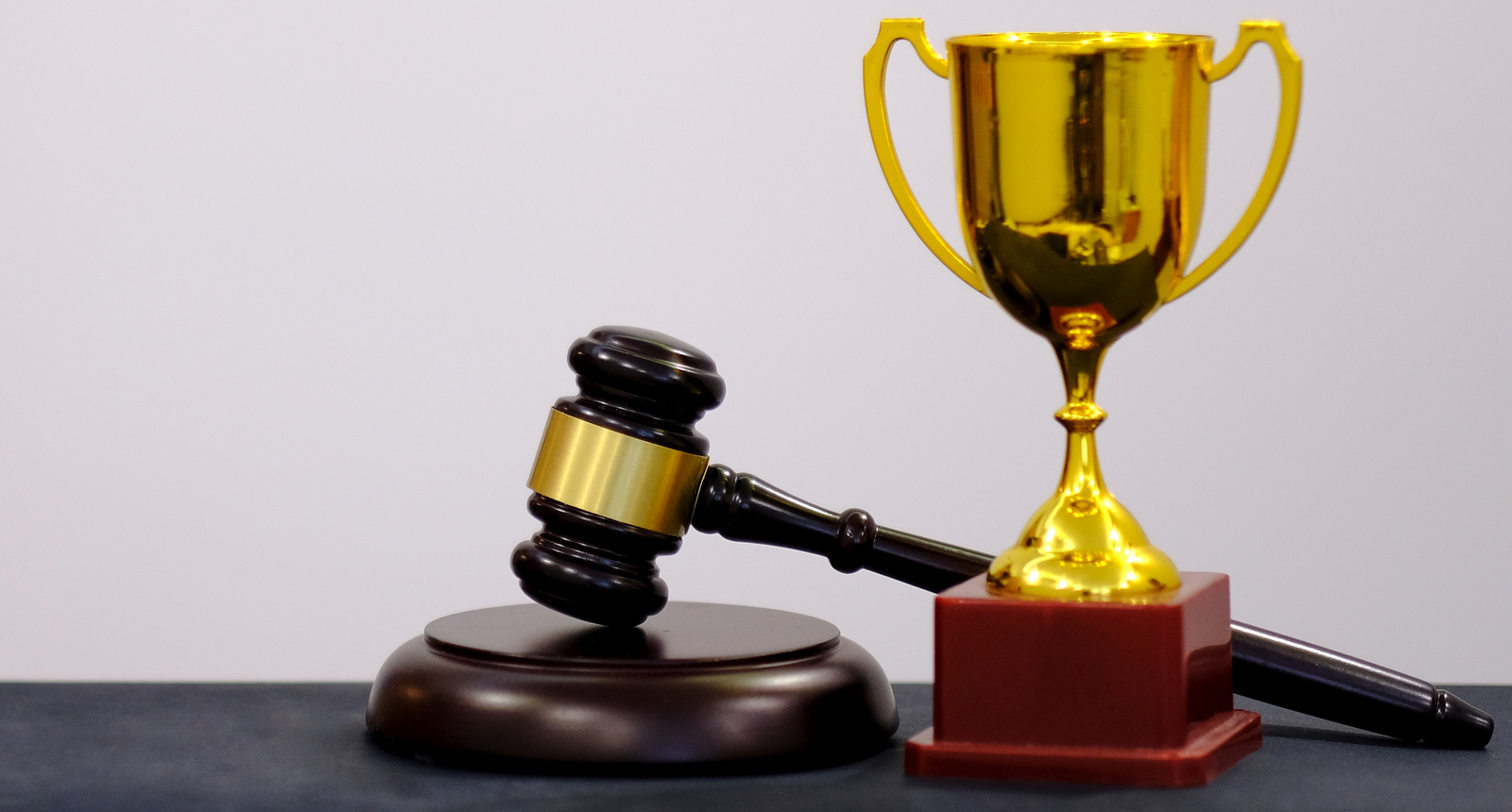 A picture of a judge's gavel with a trophy