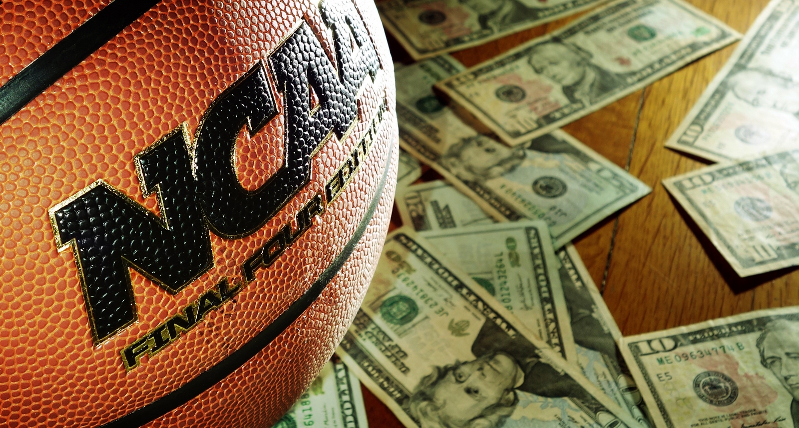 A picture of an NCAA-branded basketball with money behind it