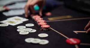 A dealer breaking down casino chips next to playing cards.