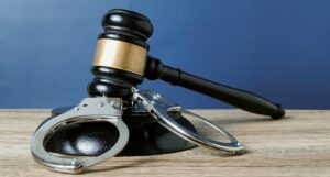 A picture of a judge's gavel and handcuffs