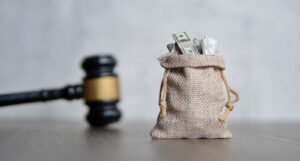 A picture of a bag of money and a judge's gavel