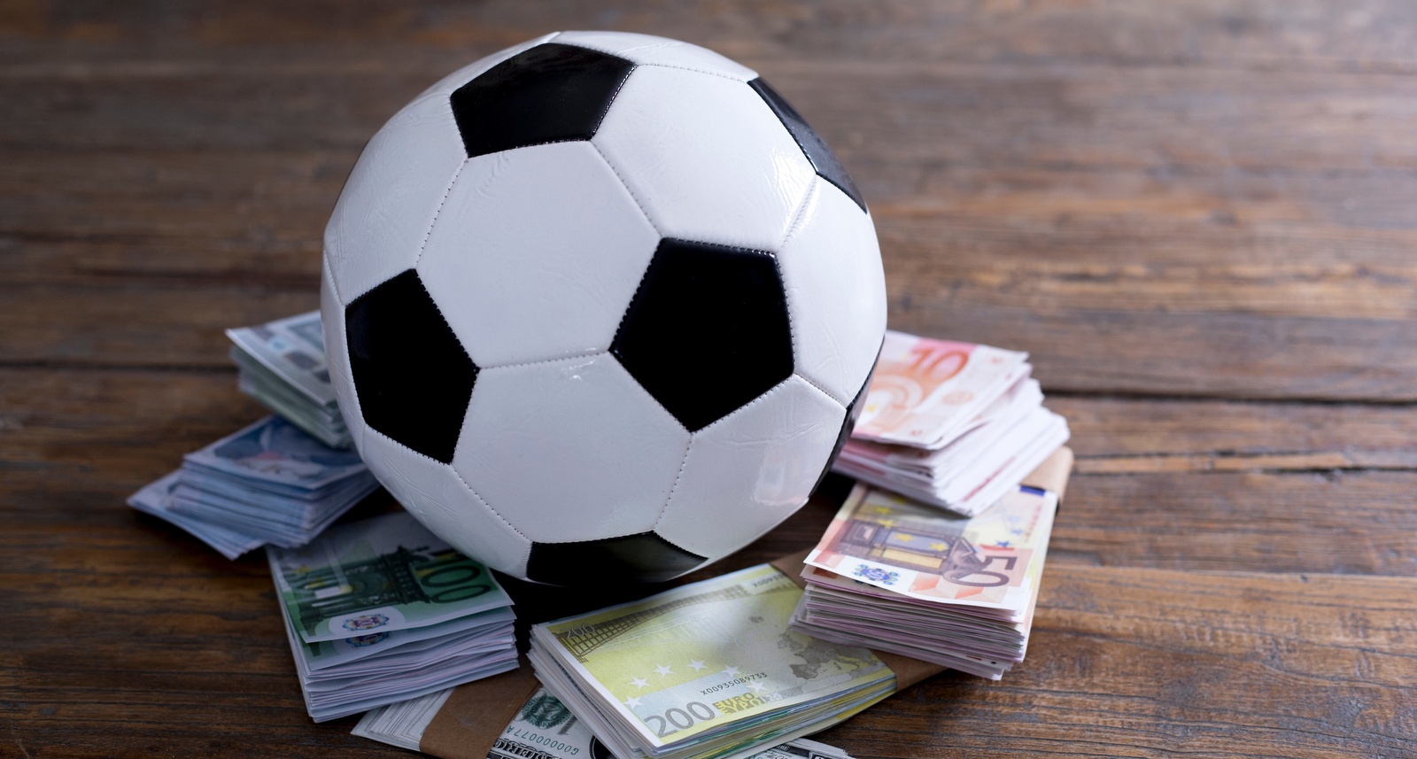 A picture of a soccer ball with money underneath it