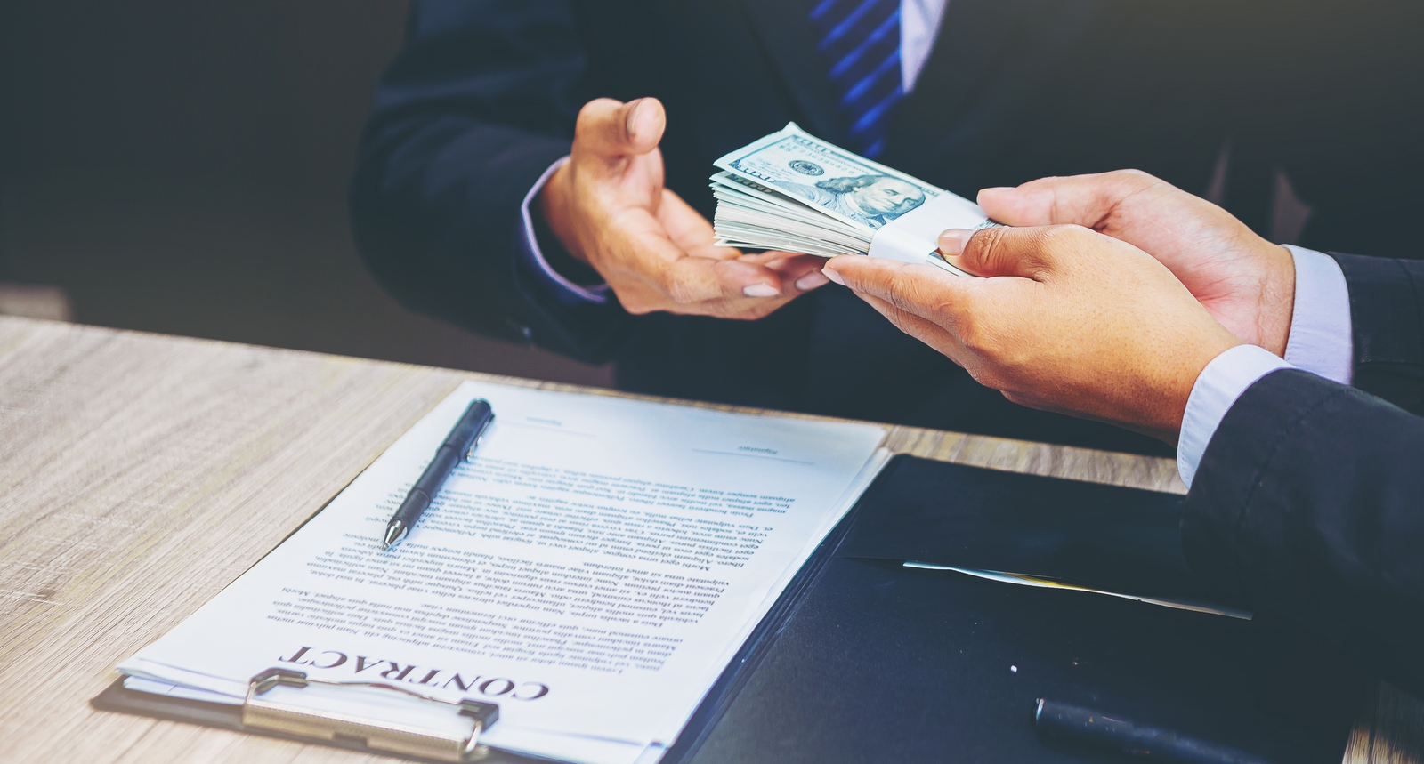 A picture of a banker handing over money for a loan